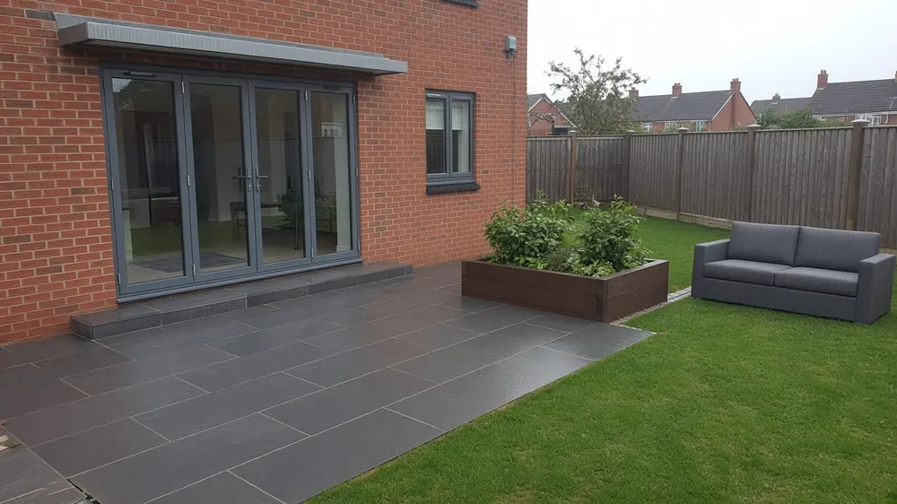 Example image of a charcoal porcelain patio outside bi-fold doors on a modern Normanby home