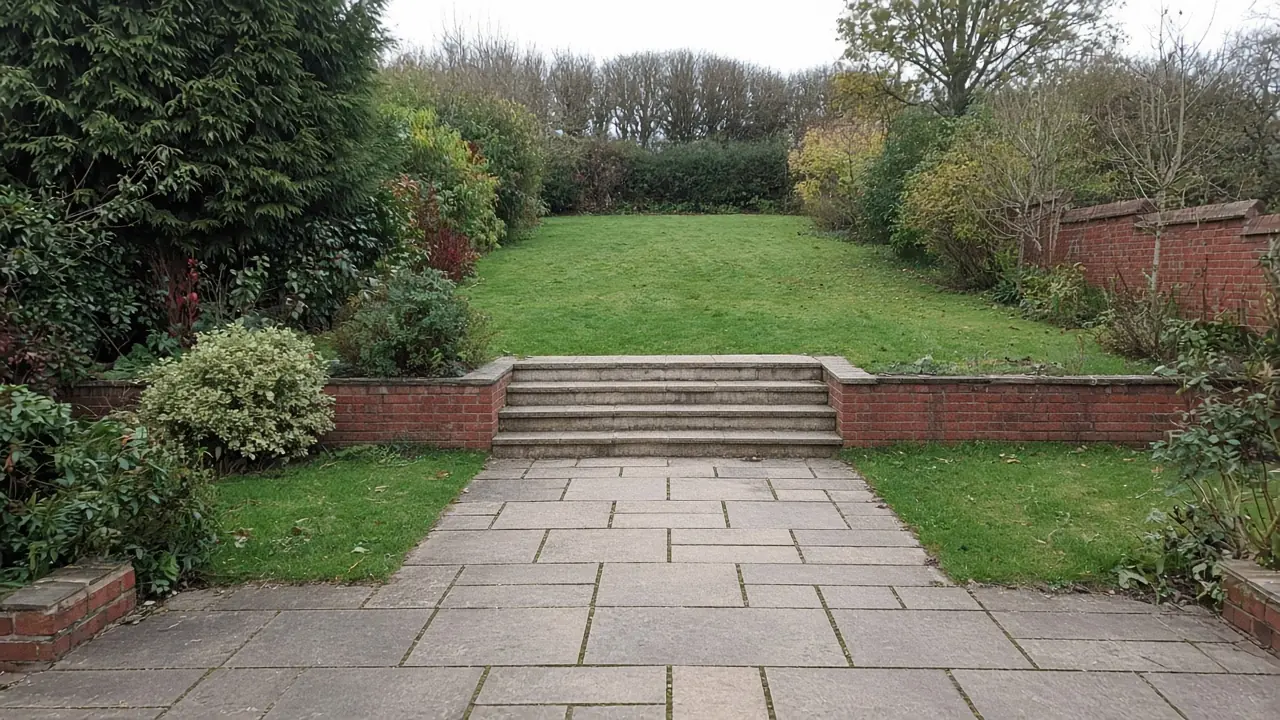 Example image: a sandstone path leading to wide stone steps between low brick walls in a long sloping garden